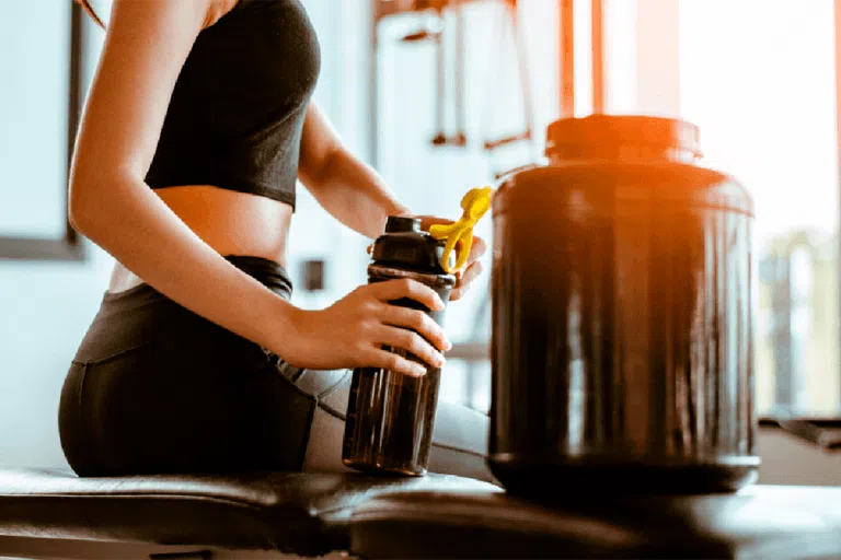 suplementos para aumentar masa muscular en piernas y gluteos en mujeres mujer bebiendo proteina whey